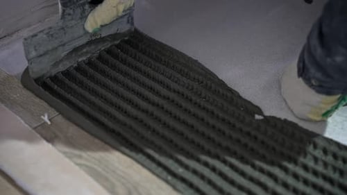 Close Up of Trowel Spreading Adhesive on Flooring