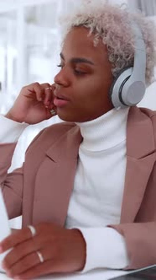 Person With Glasses Listens to Music While Working in an Office Space