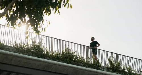 Man, running and exercise in city for fitness, healthy body and training for marathon on bridge