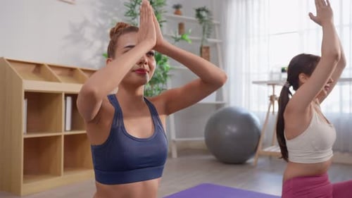 Two Women Practicing Yoga Poses in Bright Home