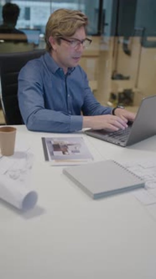 Mid-Aged Architect Typing on Laptop at Work in the Office