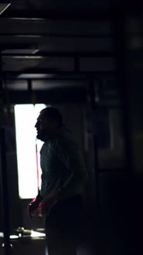 Man Doing Pushups in Dark Gym