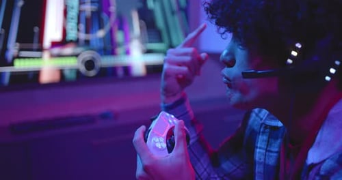 Intense Young Adult Gamer Playing Video Game at Night