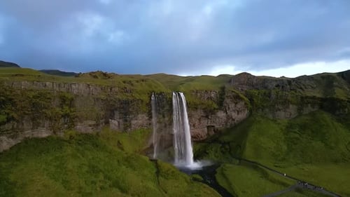 aerial panorama of Seljalandsfoss, displaying the powerful waterfall, meandering river, and vast
