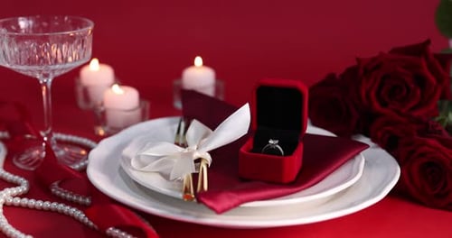 Engagement ring in box on romantic place setting