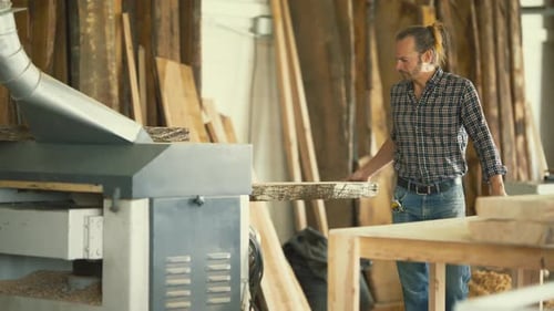 Carpenter Using a Thickness Planer Machine