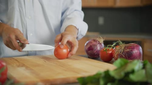 Close Up of Man Cutting Tomato