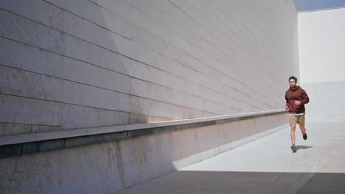 Fit Guy Running City Architecture on Sunny Day Brunette Runner Doing Cardio