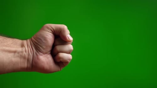 10a. A man makes a threatening fist on a green background.
