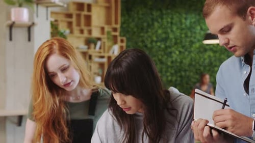 Three Young Adults Collaborating in an Office