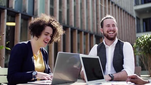 Junges Geschäftsteam arbeitet im Freien am Laptop zusammen, um Ideen für Start-ups zu entwickeln