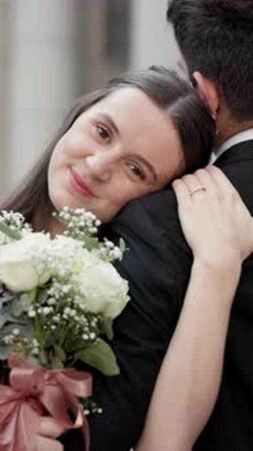 Happy couple, wedding and flowers with hug for marriage, commitment or love together in city