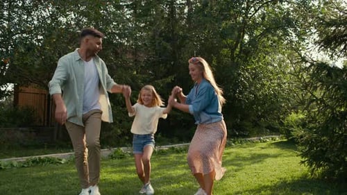 Family Walking on Grass, Raising Child in Air