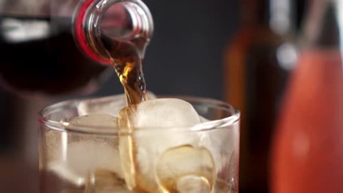 Dark Soda Poured into Glass with Ice