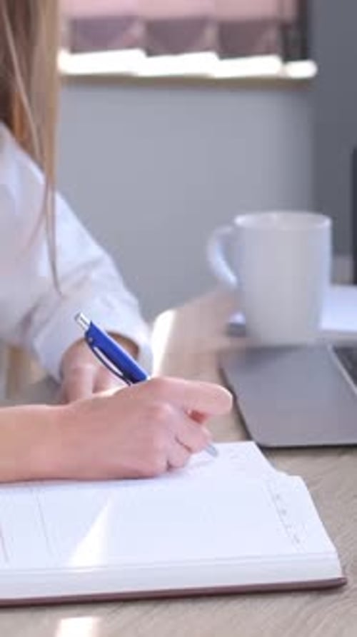 Une femme chef de bureau écrit un plan d'affaires dans un carnet Une femme au bureau