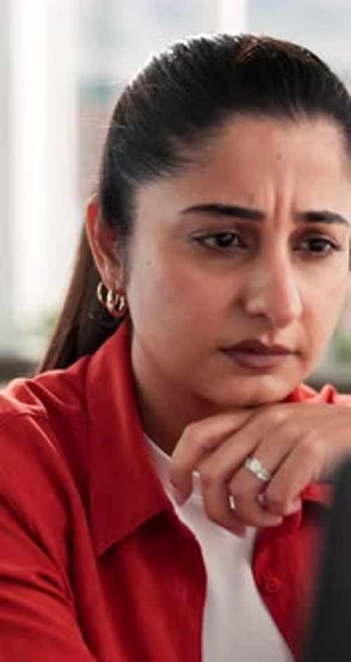 Woman Thinking in Office Wearing Orange Shirt