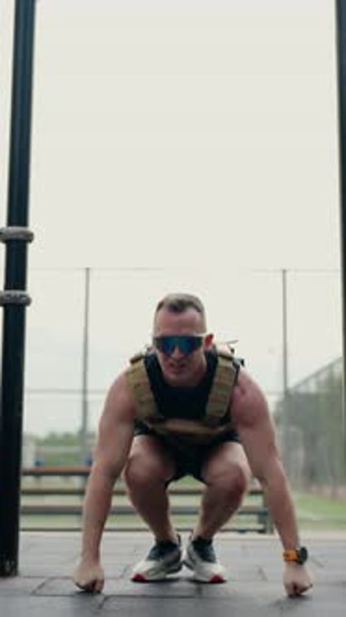 Athletischer Mann führt Burpees mit einer Gewichtsweste durch