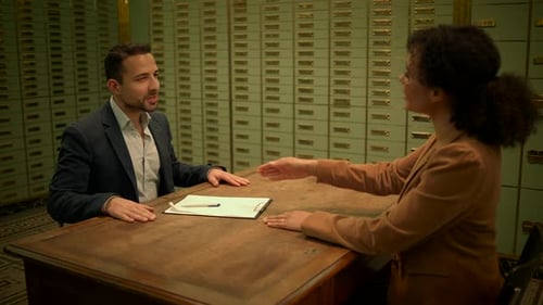Man Signs Document in Bank