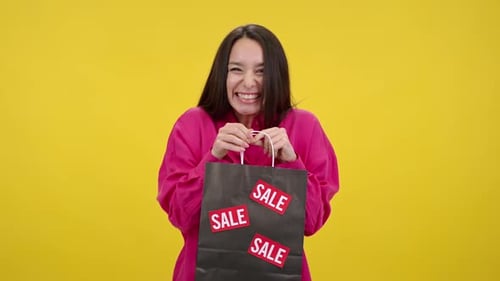 Excited Woman Holding Shopping Bag with Sale Stickers