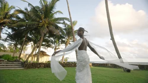 Elegant Woman Posing in White Dress on Tropical Lawn