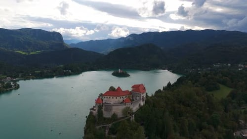 Hilltop Castle On Cliff Above Lake Bled In Slovenia - Drone Shot