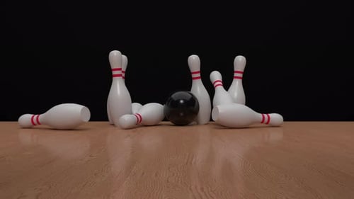 The bowling ball travels down the bowling alley, hits and knocks down the bowling pins. Strike.
