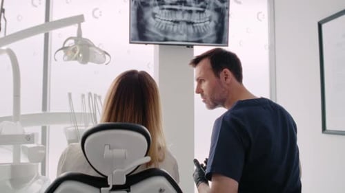 Dentist Explaining Dental X-ray to Patient in Office