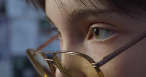 Eyes in Eyeglasses Closeup Girl Sits in Front of a Computer Monitor