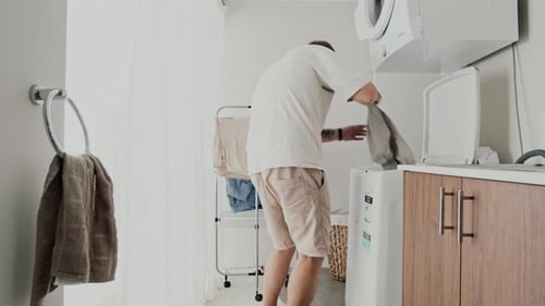 Man picking clothes from washing machine