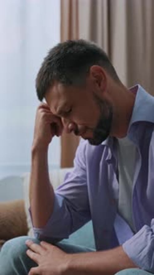A Contemplative Man Appears Relaxed Within a Modern Living Room Reflecting Deeply on Life