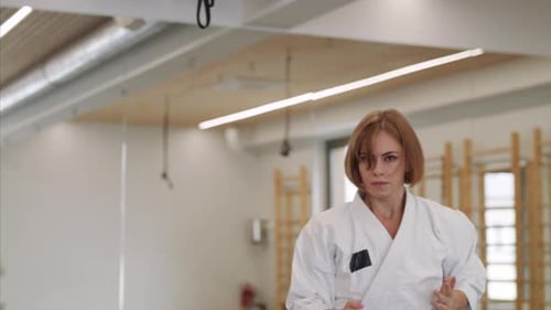Young Woman Practising Karate Indoors in Gym