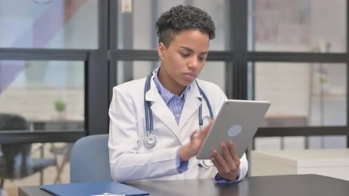 Female Doctor Uses Tablet in Workplace Setting