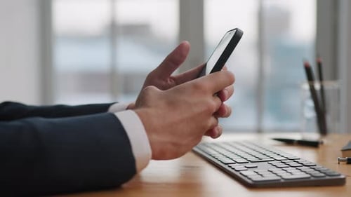 Man hands working on mobile phone in office typing message online