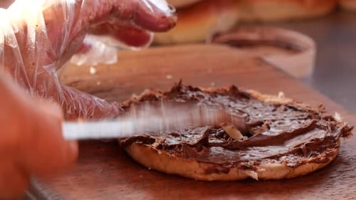 Chocolate Spread Being Applied to a Bagel
