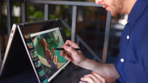 Freelancer Retoucher Man Works on Convertible Laptop Computer with Photo Editing Software Using