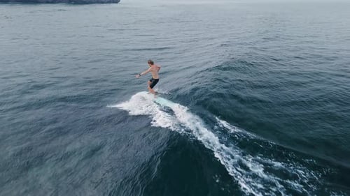 Surfer Rides on Surfboard on Ocean Wave Surfing Men Riding on Longboard Drone View