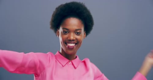 Woman with Afro Dancing Happily in Pink Shirt