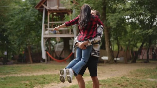 Couple Lifts Up Girlfriend in Countryside