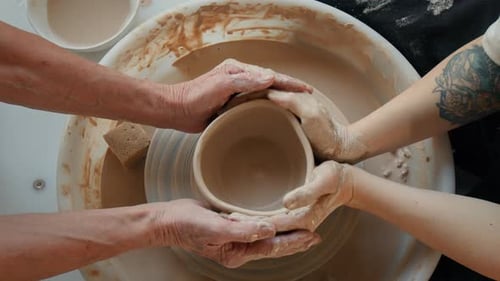 Paire de jeunes et de personnes âgées méconnaissables travaillant ensemble sur la roue de Potter