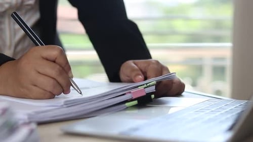 Business Person Signing Documents at Desk