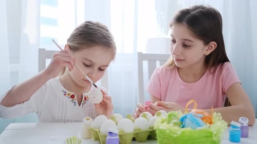 Zwei Schwestern färben Eier für Ostern