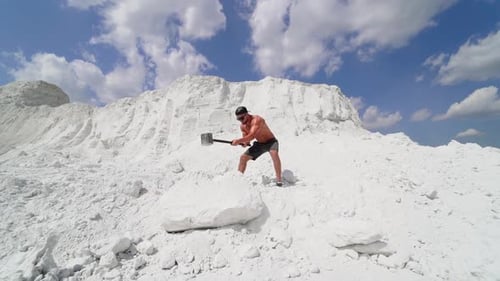 Man Hitting Stone With Hammer. Strong sport man with naked torso hitting stone