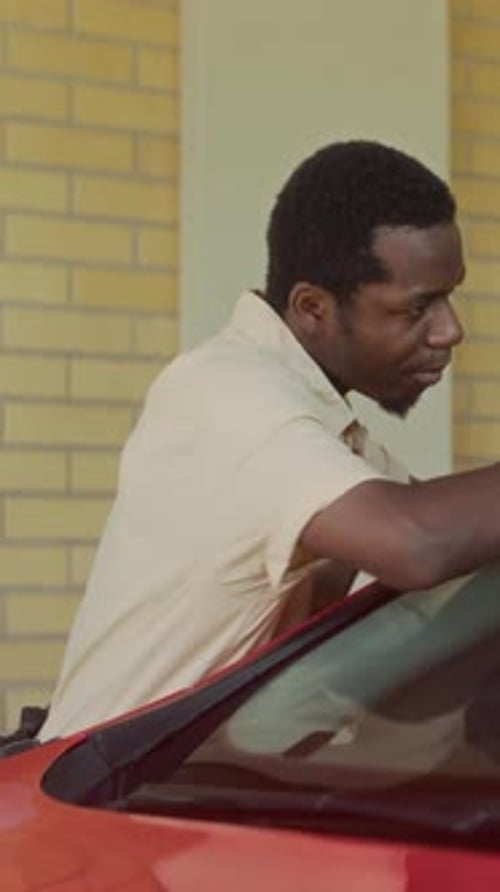 Vertical of Mechanic Wiping Red Car Windshield with Cloth