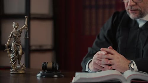 El juez señala con el dedo el documento y golpea el escritorio con un mazo de madera después de escuchar mientras