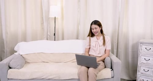 Smiling Woman Video Calling on Laptop at Home