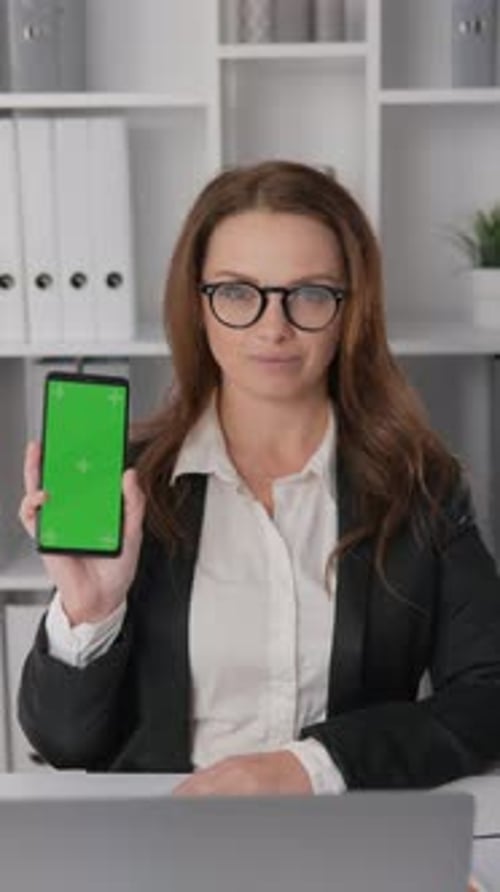 Businesswoman Working in Office Holding Phone Showing Green Smartphone Chroma Key Screen Advertising