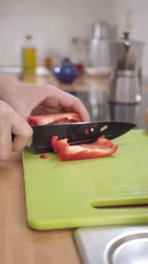 Unerkennbarer kaukasischer Mann, der zu Hause Gemüse hackt Konzept der gesunden Ernährung