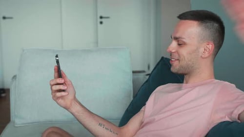 Young Adult Video Chatting on Smartphone at Home