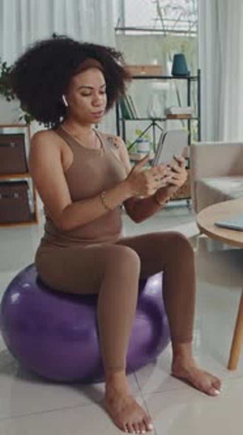 Woman Using Tablet While Sitting on Exercise Ball