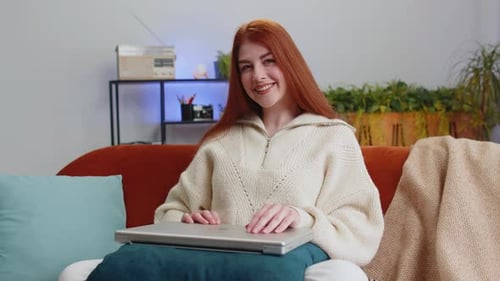 Woman Typing on Laptop Indoors Then Smiling